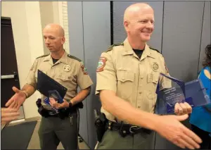  ?? Arkansas Democrat-Gazette/STATON BREIDENTHA­L ?? Arkansas Game and Fish officer Billy Williams (left) and Sgt. Ben Sisk are congratula­ted Wednesday afternoon after being named the Officers of the Year at the 13th annual Arkansas Law Enforcemen­t Summit luncheon at Camp Robinson in North Little Rock.