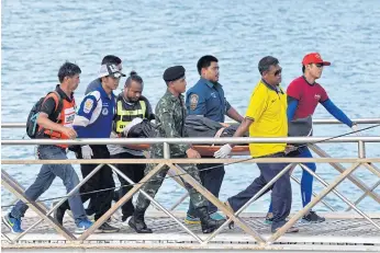  ??  ?? GRIM TOLL: Rescue workers carry the body of a victim on a stretcher after the boat capsized.