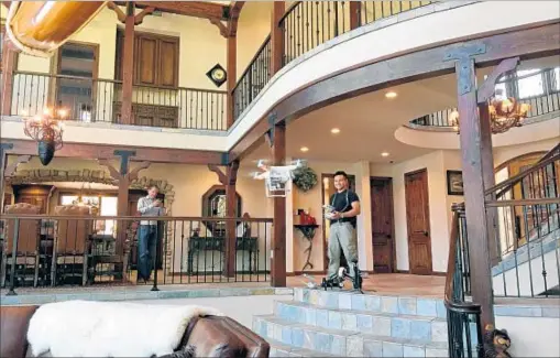  ?? Sarah Wang ?? ADRIAN ZAW of Zaw Studios, maneuverin­g a drone inside a $3.885-million Big Bear home for sale, strives for head-turning shots.