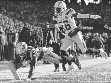  ?? Adam Glanzman / Getty Images ?? The Patriots’ Sony Michel beats the Chargers’ Casey Hayward to the pylon on his way to scoring the second of three touchdowns.