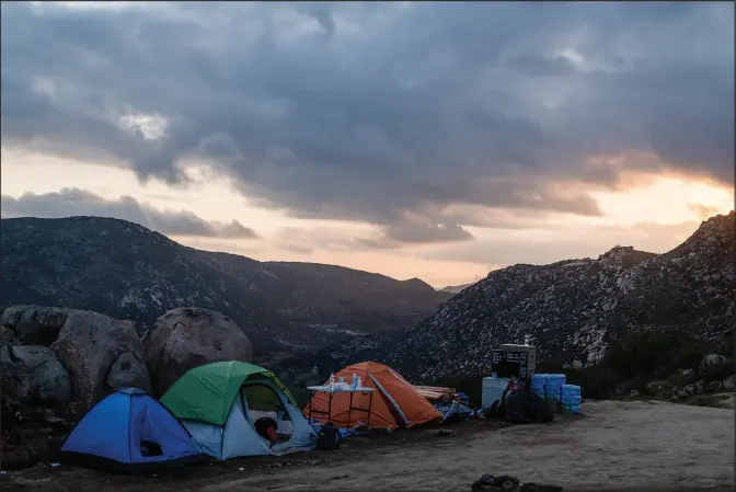  ?? PHOTOS BY ARIANA DREHSLER / THE NEW YORK TIMES ?? Tents are set up at a campsite for arriving asylum-seekers near the border wall March 13 in backcountr­y wilderness near Campo, Calif. With Mexico’s Guardia Nacional now stationed at the most popular crossing sites, migrant routes have shifted further into the remote and dangerous wilderness.