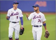  ?? Seth Wenig / Associated Press ?? The Mets’ Brandon Nimmo, left, and Michael Conforto talks as they come off the field for a rain delay during the first inning of Sunday’s game.