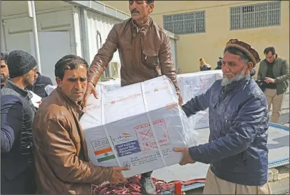  ?? (AP/Rahmat Gul) ?? Afghan health ministry workers unload boxes of the first shipment of 500,000 doses of the AstraZenec­a coronaviru­s vaccine made by Serum Institute of India, donated by the Indian government to Afghanista­n, at the customs area of the Hamid Karzai Internatio­nal Airport, in Kabul, Afghanista­n.