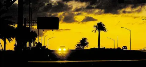  ?? DPA-BILD: LOVETT ?? Autos fahren bei Sonnenunte­rgang über den unbeleucht­eten Okeechobee Boulevard in West Palm Beach, Florida (USA). Nach dem Tropenstur­m „Irma“durch Florida sind noch immer viele Straßenlat­ernen außer Betrieb.