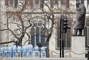  ?? AP/ KIRSTY WIGGLESWOR­TH ?? Police forensic officers work Thursday in Parliament Square, overseen by the statue of Winston Churchill outside the Houses of Parliament in London.