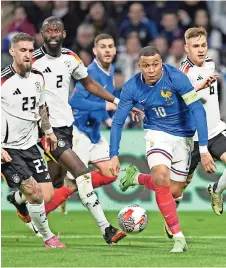  ?? ?? Kylian MBAPPÉ (der.) controla el balón ante la marca de rivales