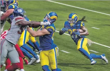  ?? Robert Gauthier Los Angeles Times ?? DARRELL HENDERSON of the Rams runs against the Giants on Sunday. Offensive holding calls were down from 235 in the f irst three weeks last season to 94 in the same span this year, ref lecting an overall trend.