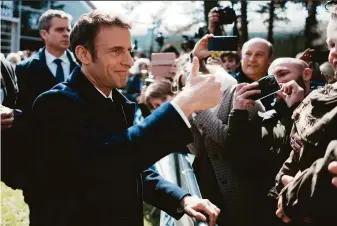  ?? Thibault Camus / Associated Press ?? French President Emmanuel Macron greets supporters after casting his ballot in Le Touquet. Macron will compete with far-right nationalis­t Marine Le Pen in the runoff vote on April 24.