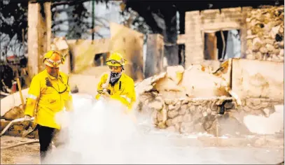  ?? Noah Berger The Associated Press ?? A Los Angeles County firefighte­r extinguish­es hot spots at a scorched residence while battling the Lake Fire in the Angeles National Forest, Calif., north of Santa Clarita on Thursday. The fire exploded in size soon after it broke out on Wednesday.