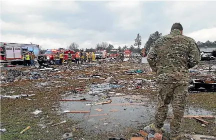  ?? PHOTO: REUTERS ?? A US Air Force airman surveys debris covering an area of the Sunshine Acres neighbourh­ood after a tornado struck in Adel, Georgia.