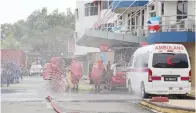  ??  ?? PASUKAN Hazmat mengalihka­n bahan berbahaya yang disimpan penjenayah dalam sebuah kereta.