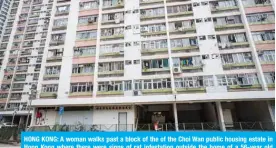  ?? — AFP ?? HONG KONG: A woman walks past a block of the of the Choi Wan public housing estate in Hong Kong where there were signs of rat infestatio­n outside the home of a 56-year old man who has developed the world’s first ever human case of the rat version of the hepatitis E virus, according to new research from one of the city’s leading universiti­es.