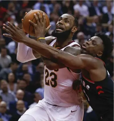  ?? RICK MADONIK/TORONTO STAR ?? Raptor OG Anunoby leans on a driving LeBron James of the Cavaliers in Thursday night’s game at the Air Canada Centre.