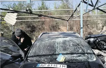  ?? LEO CORREA AP ?? Dmytro Pocishchuk checks his car, which was damaged after a Russian attack in Zaporizhzh­ia, Ukraine, on Saturday as unrelentin­g shelling continues in the region.