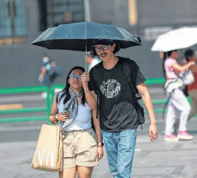  ?? HENRY ROMERO • REUTERS ?? People cover themselves with umbrellas as they walk past the Palacio de Bellas Artes (Palace of Fine Arts) during high temperatur­es, in Mexico City, Mexico May 9, 2024.