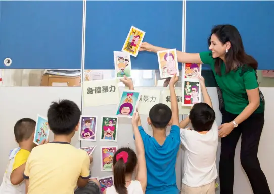  ??  ?? FAMILY AFFAIR Mahnaz Lee and the children of abused women play a game about family harmony