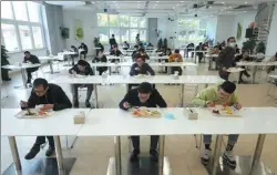  ?? GAO ERQIANG / CHINA DAILY ?? Left: Employees of FESTO China keep a distance at lunch tables after the company resumed operations in Shanghai.