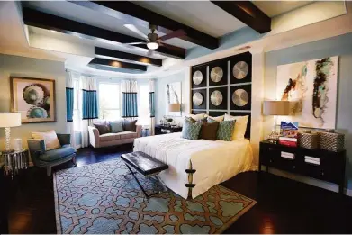  ?? Mark Mulligan photos / Houston Chronicle ?? Above: A painted ceiling tray and straight exposed beams were chosen for the master bedroom.