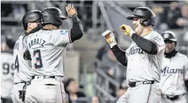  ?? WENDELL CRUZ USA TODAY Sports ?? Marlins third baseman Jake Burger, right, is greeted by Luis Arraez and Nick Fortes after hitting a three-run home run in the third inning against the Yankees on Wednesday.