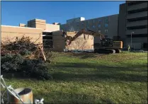  ?? RICHARD PAYERCHIN — THE MORNING JOURNAL ?? Trees and shrubs sit in a pile as an excavator takes down the brick facade Nov. 4to commence demolition at the west building of the former St. Joseph Community Center, 205W. 20th St., Lorain.