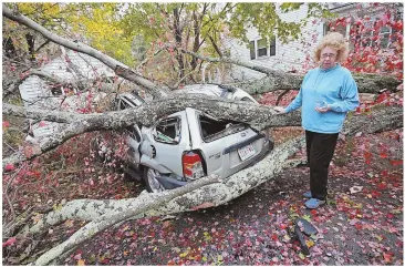  ?? STAFF PHOTO, RIGHT, BY MATT STONE; BELOW AND BOTTOM, BY FAITH NINIVAGGI ?? DESTRUCTIO­N: Deb Coulsey of Abington, right, looks at the damage caused by a limb landing on her car during the windy storm that worked through the area Sunday into yesterday morning. A tree fell on top of a Methuen house, below, destroying the rear of...