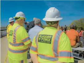  ?? KARL MERTON FERRON/STAFF PHOTOS ?? Constructi­on employees listen as Maryland and MDOT officials hold a Work Zone Awareness Week kickoff on the westbound I-70 bridge over I-695.