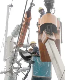  ??  ?? ELECTRICIA­NS from the MERALCO maintain a secondary transmissi­on line in Manila.