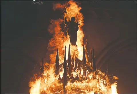  ?? (AP/Esteban Felix) ?? The statue of a saint is engulfed in flames after protesters torched the San Francisco de Borja church, a favorite of Chile’s national police force, on the one-year anniversar­y of the start of anti-government mass protests over inequality in Santiago.