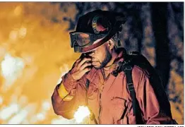  ?? JOSH EDELSON/GETTY-AFP ?? An inmate firefighte­r stops for a moment Friday as a wildfire burns in Redding, Calif.