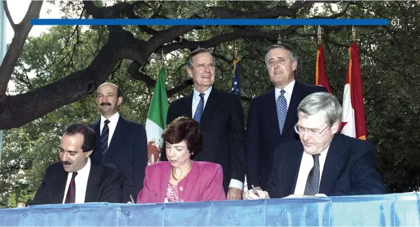  ?? Presidenti­al Library Courtesy of the George Bush ?? Mexican President Carlos Salinas, U.S. President George Bush and Prime Minister Brian Mulroney watch as trade ministers Jaime Serra Puche, Carla Hills, and Michael Wilson signing the NAFTA for their three countries in San Antonio, Texas in October 1992.