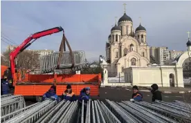  ?? Photograph: Reuters ?? Workers in front of the Church of the Icon of the Mother of God in Moscow, where the funeral of Alexei Navalny is expected to take place.