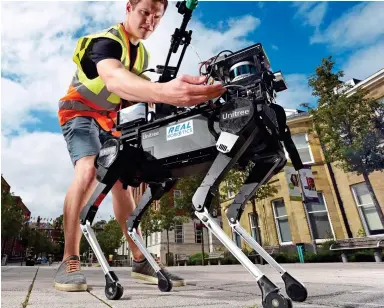  ??  ?? PET PROJECT: Leeds University researcher Nick Fry gets a disinfecti­ng robot dog ready for action