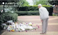  ??  ?? A man looks at floral tributes in Tarleton