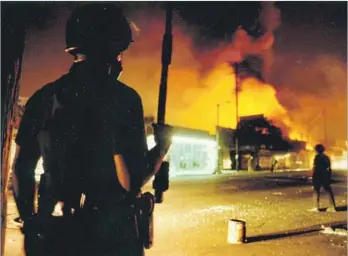  ?? Gary Friedman Los Angeles Times ?? OFFICER Delwin Fields guards the intersecti­on of Central Avenue and 46th Street on April 30, 1992. Los Angeles Police Department officials say the response to such events now would be much different.