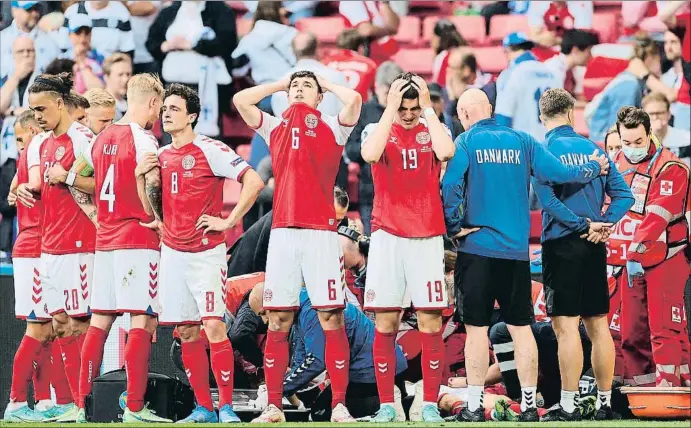  ?? FRIEDEMANN VOGEL / AFP ?? Els futboliste­s de Dinamarca envolten Eriksen, que és a terra, mentre els metges l’atenen