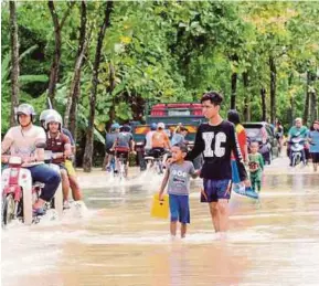  ?? [FOTO HAFIZUDIN MOHD SAFAR/BH] ?? Jalan utama ke Kampung Repoh ditenggela­mi air berikutan hujan lebat dua hari lalu di Perlis.