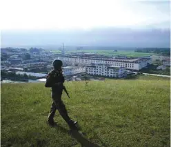  ??  ?? KACHIN STATE: In this photograph taken on July 26, 2016, a Myanmar armed rebel secures a hilltop overlookin­g Mai Ja Yang where Myanmar ethnic rebel leaders and representa­tives are gathering for a four day summit in the town controlled by the Kachin...