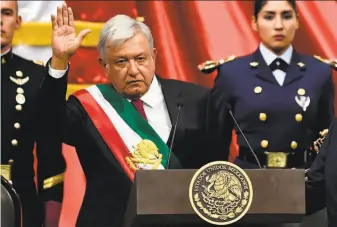  ?? Alfredo Estrella / AFP / Getty Images ?? Andres Manuel Lopez Obrador, Mexico’s new president, waves to members of Congress after receiving the presidenti­al sash in Mexico City. He rose to prominence as a protest leader.