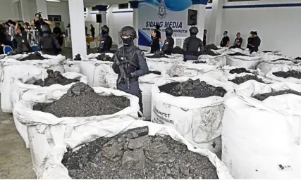  ??  ?? Dark cargo: The RM2.4bil in cocaine mixed with the coal found in three containers on display for the media at the Bayan Baru police station, Bayan Baru, Penang.