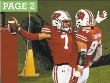  ?? Morry Gash / Associated Press ?? Wisconsin receiver Danny Davis III celebrates his TD catch with tight end Jake Ferguson in the Badgers’ win over Illinois.