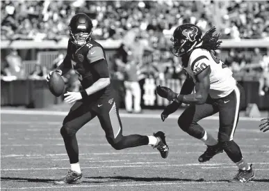  ?? Associated Press ?? Jacksonvil­le Jaguars quarterbac­k Blake Bortles, left, looks for a receiver as he is pressured by Houston Texans defensive end Jadeveon Clowney (90) during the first half of an NFL football game Dec. 17 in Jacksonvil­le, Fla. Clearly frustrated following...