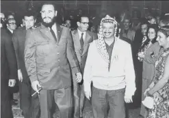  ??  ?? This file photo taken on Dec 14, 1974 shows Palestine Liberation Organizati­on (PLO) chairman Yasser Arafat (right) walking with Castro during his visit to Cuba.