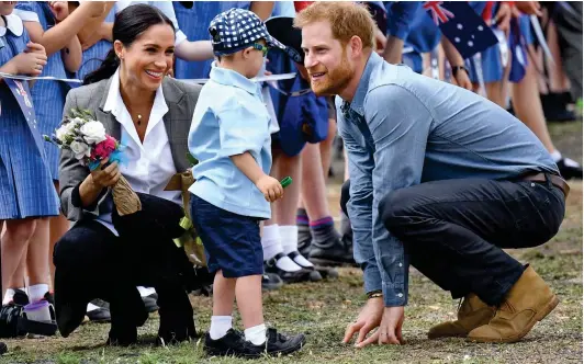  ??  ?? Who’s a cheeky boy? Harry and Meghan are enchanted by Luke Vincent, five, as he greets them in Dubbo yesterday