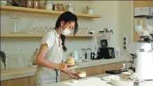  ?? HE QI / CHINA DAILY ?? A barista makes coffee at Lili Time cafe at Shanghai’s Qiantan Taikooli mall on Saturday.