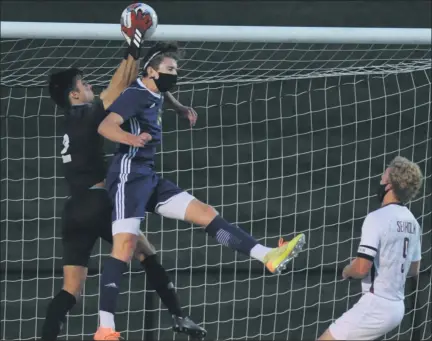  ?? KEN SWART PHOTOS — FORMEDIANE­WS GROUP ?? Birmingham Seaholm goalkeeper Adam Schmidt, left, makes the save over Stoney Creek’s Will Knish, middle, as Seaholm’s Ben Slazinski looks on during Tuesday’s OAA Red match, which ended in a 1-1draw. Stoney Creek is 2-2-1this season, while Seaholm is now 2-1-2.