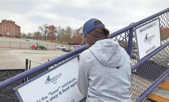  ?? SUBMITTED ?? Amber Asberry, marketing and sales director with the Cookeville Visitor's Bureau, places a sign urging COVID-19 safety and caution at Tennessee Tech's Tucker Stadium in preparatio­n for this week's Bluecross Bowl championsh­ip games.