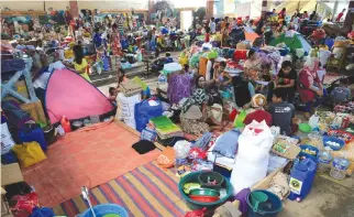  ??  ?? RESIDENTS WHO have left their homes in Marawi City to avoid the intense fighting are seen inside the evacuation center n Iligan City, June 18.