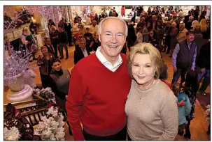  ?? Arkansas Democrat-Gazette/RACHEL O’NEAL ?? Gov. Asa Hutchinson and his wife, Susan, pose during last Sunday’s open house at the Governor’s Mansion. A pair of murals on display with the Christmas decoration­s represent their early courtship.