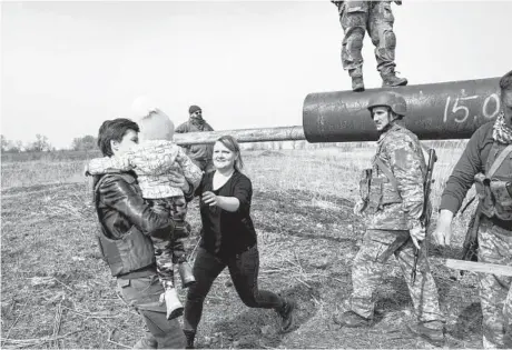  ?? RONALDO SCHEMIDT/GETTY-AFP ?? A refugee runs toward her child after soldiers helped them on Thursday near Kyiv, Ukraine.