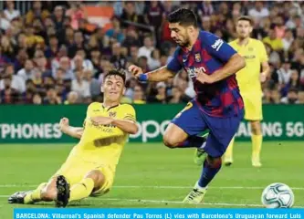  ?? — AFP ?? BARCELONA: Villarreal’s Spanish defender Pau Torres (L) vies with Barcelona’s Uruguayan forward Luis Suarez during the Spanish league football match between FC Barcelona and Villarreal CF at the Camp Nou stadium in Barcelona.